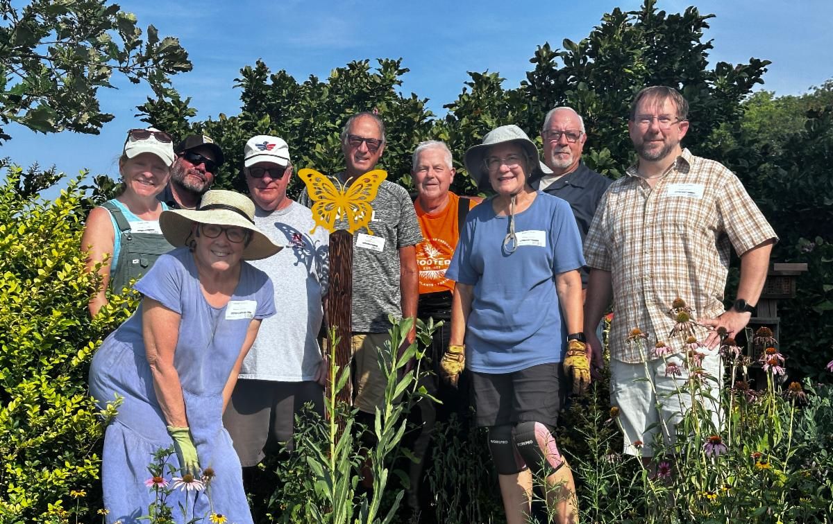 group of people standing in a garden 