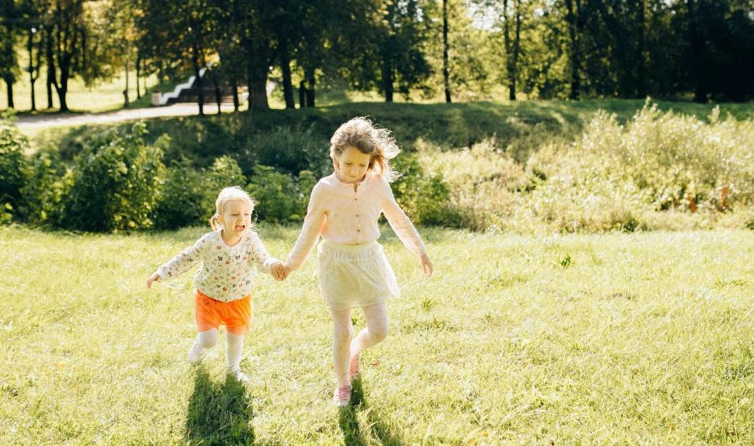 two kids running in grass