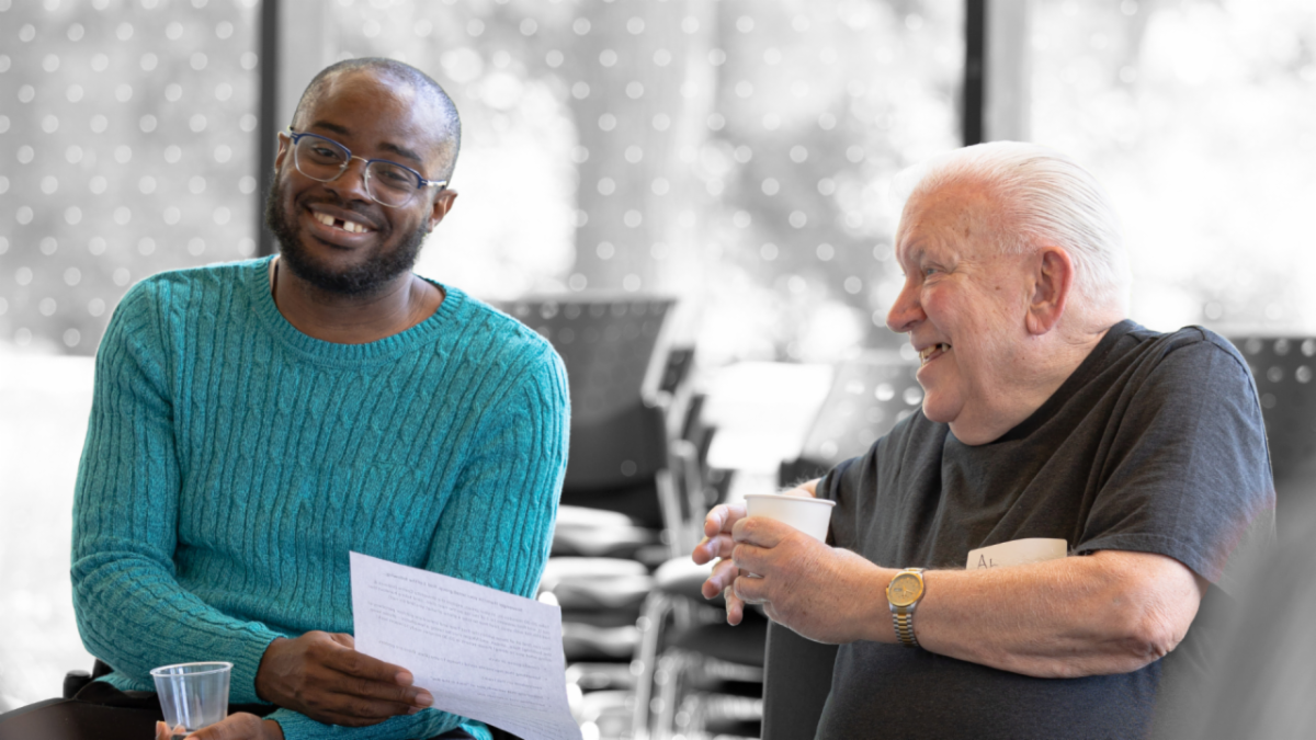 A young man and an older adult laughing