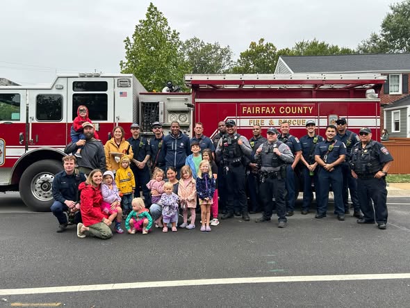 Group poses in front of firetruck. 