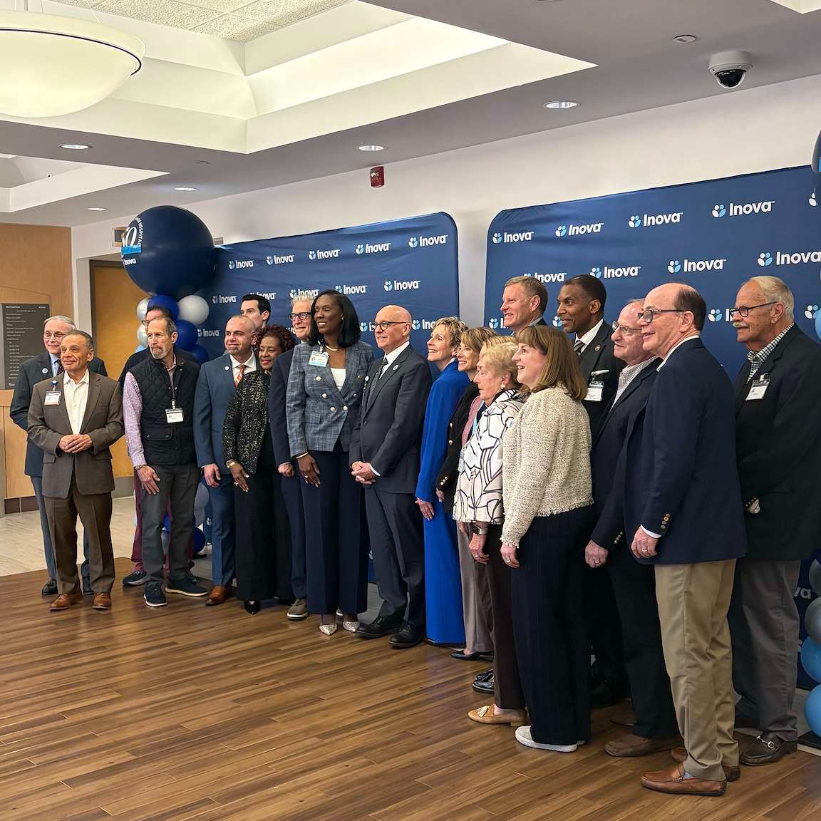 Group poses in front of blue backdrop reading "Inova".