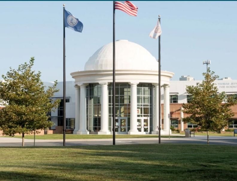 School building with flag poles in front.
