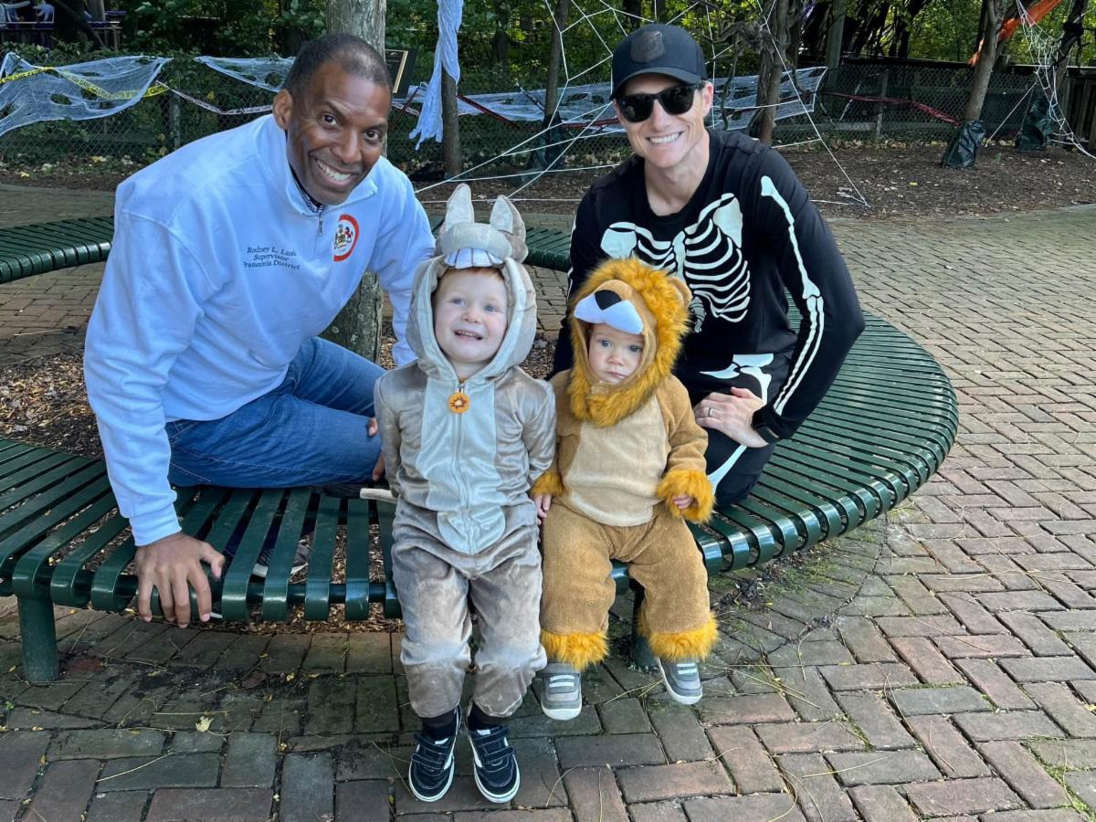Two adults pose with two children in Halloween costumes.