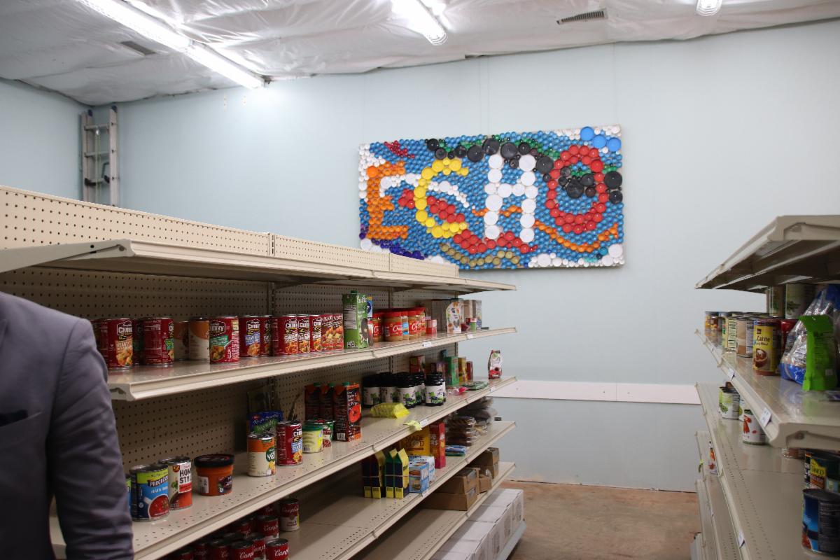 Room with shelves holding cans and a photo on the wall reading "ECHO".