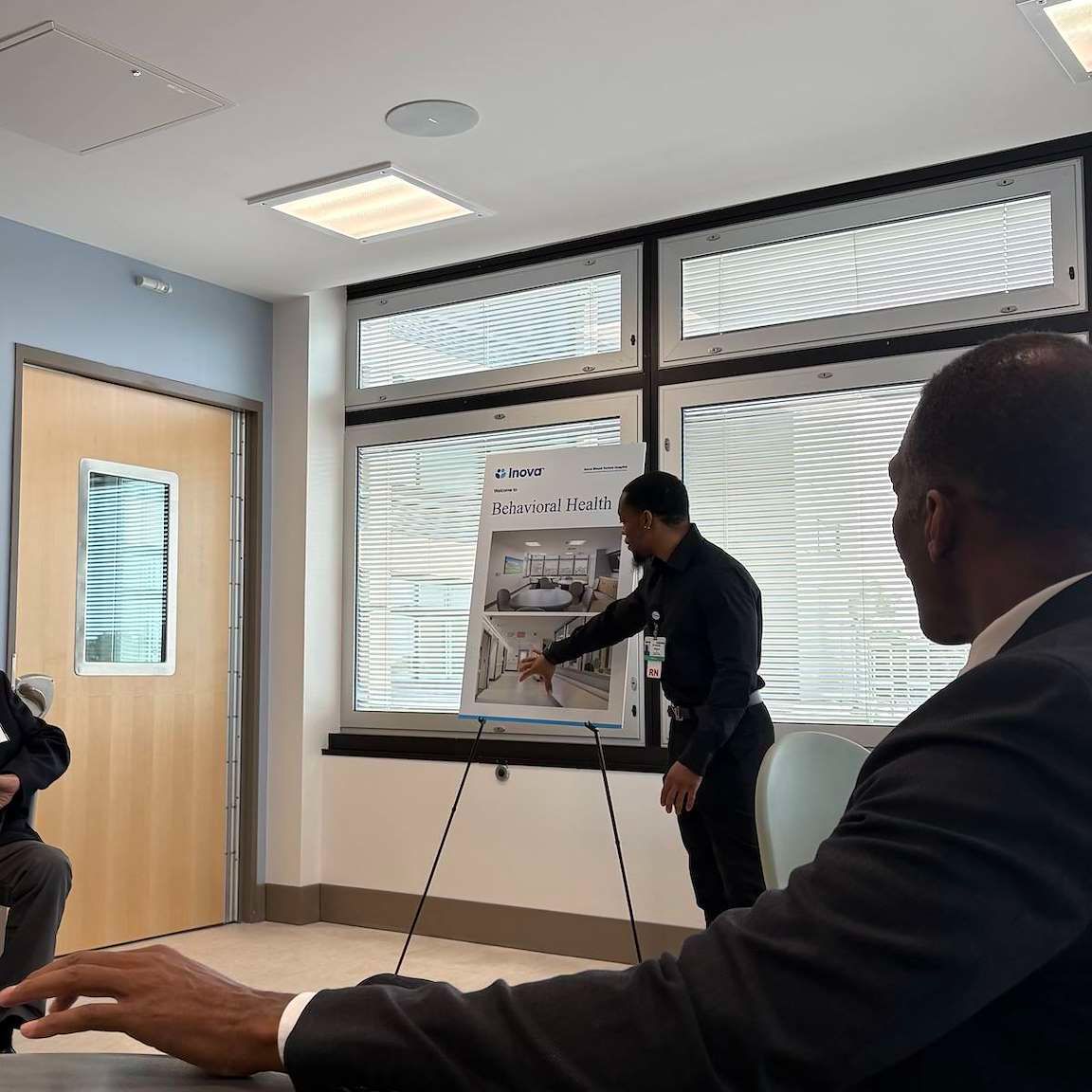 Man presents behavioral health information on a poster.