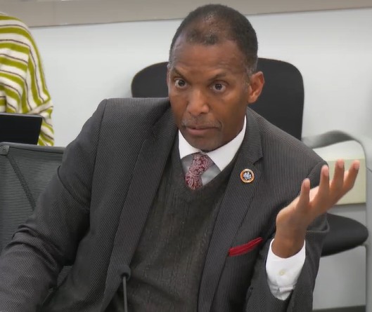 Man in suit speaking.