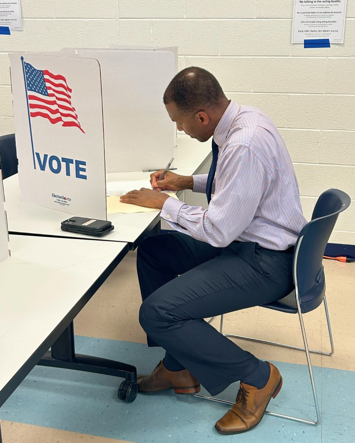 Man sits at table and writes.