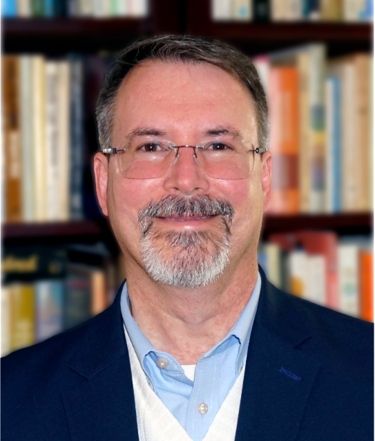 Man with glasses smiles. 