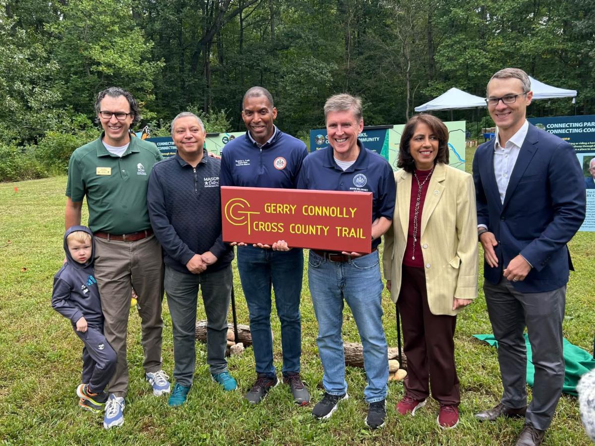 Group poses with sign. 