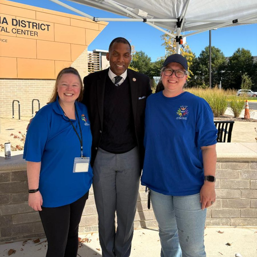 Three people pose under tent.