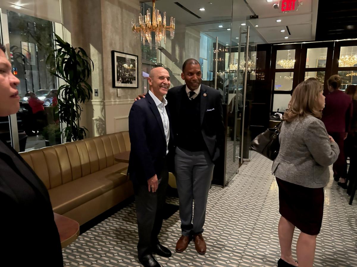 Two men in suits pose.