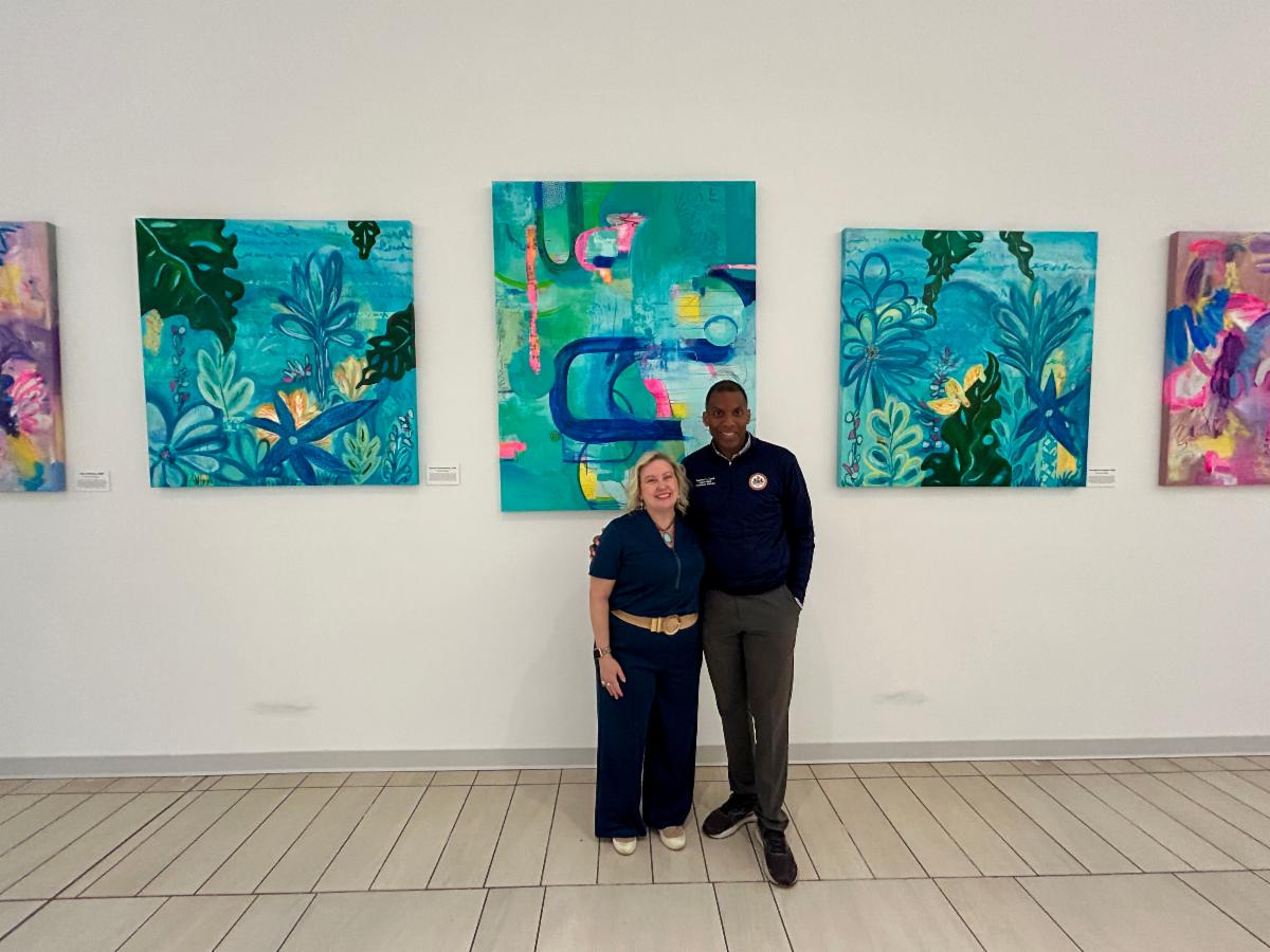 Two people stand in front of art gallery.