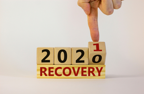 Business concept of new year 2021 recovery. Male hand flips a wooden cube and changes the inscription  recovery 2020  to  recovery 2021 . Beautiful white background_ copy space. Recovery 2021 symbol.