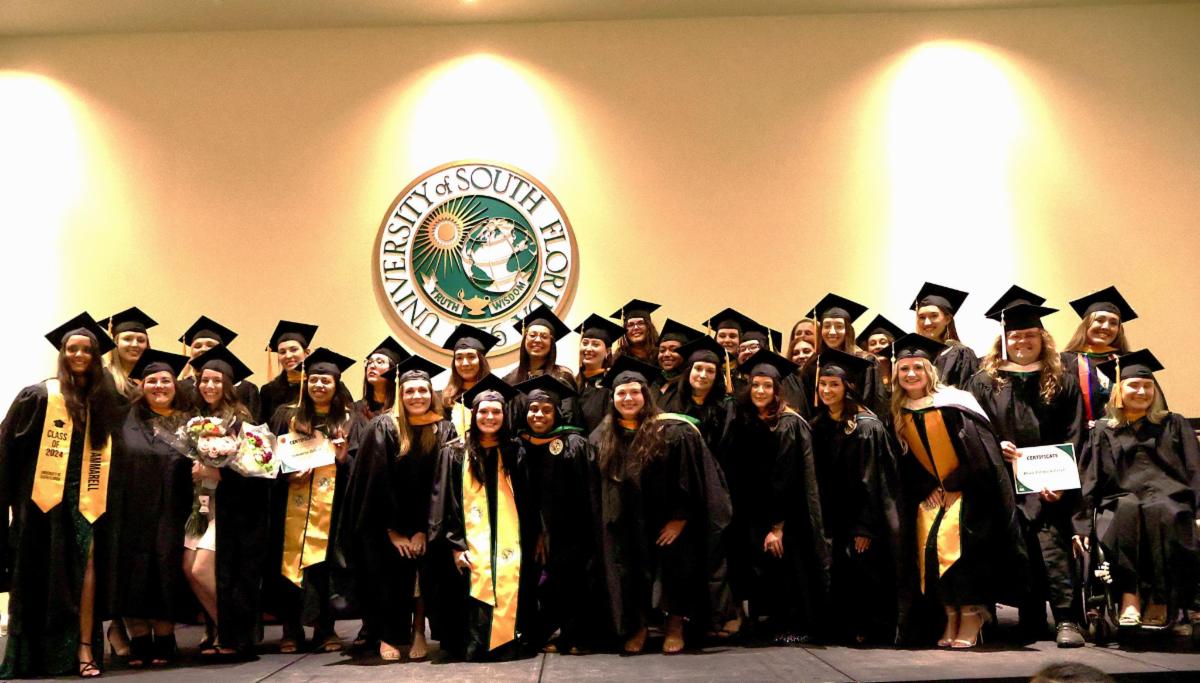 Graduates in cap and gown on stage