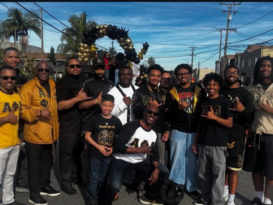 The Mu Chi Chapter of Alpha Phi Alpha Fraternity Incorporated walking alongside Long Beach Mayor Rex Richardson in the Long Beach MLK Parade