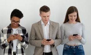 Millennial phone users business people group standing in row using smart...