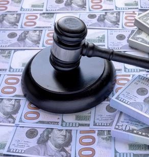 Judge gavel on a piles of dollar banknotes. Wood Gavel and Sound Block or Round Block for Judge Lawyer on top of American money. Concept  lawsuit cost and settlement