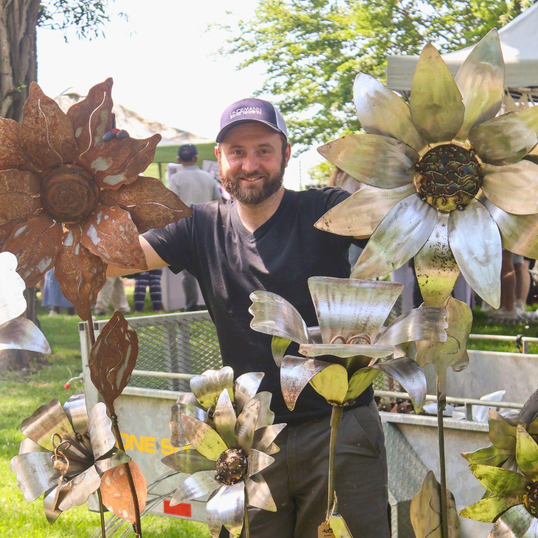Man standing in front of a display of garden ornaments