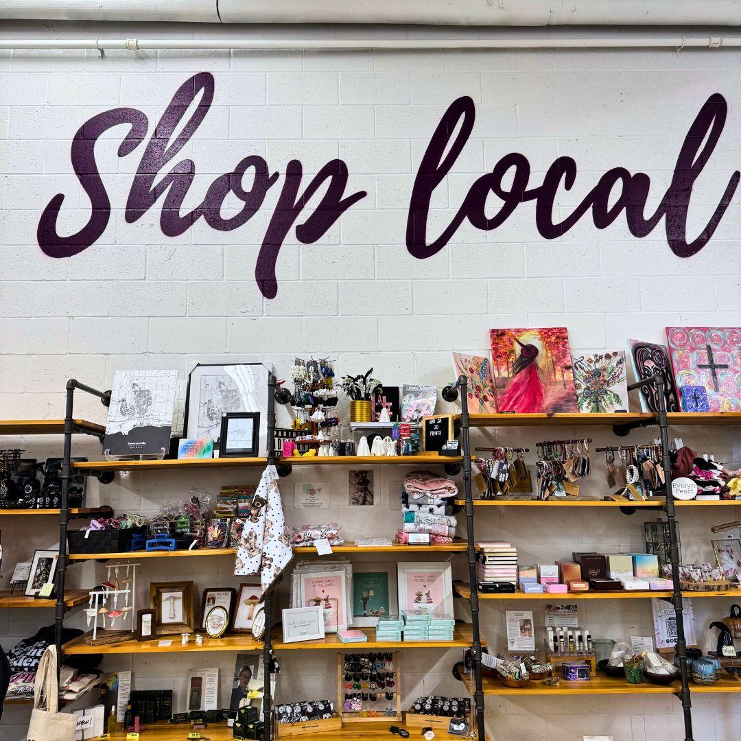 store shelves with a 'shop local' sign above