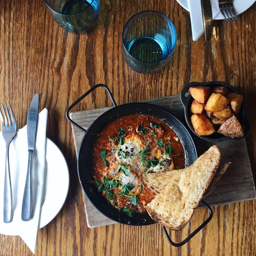 plates of food on a table with cutlery and cups 