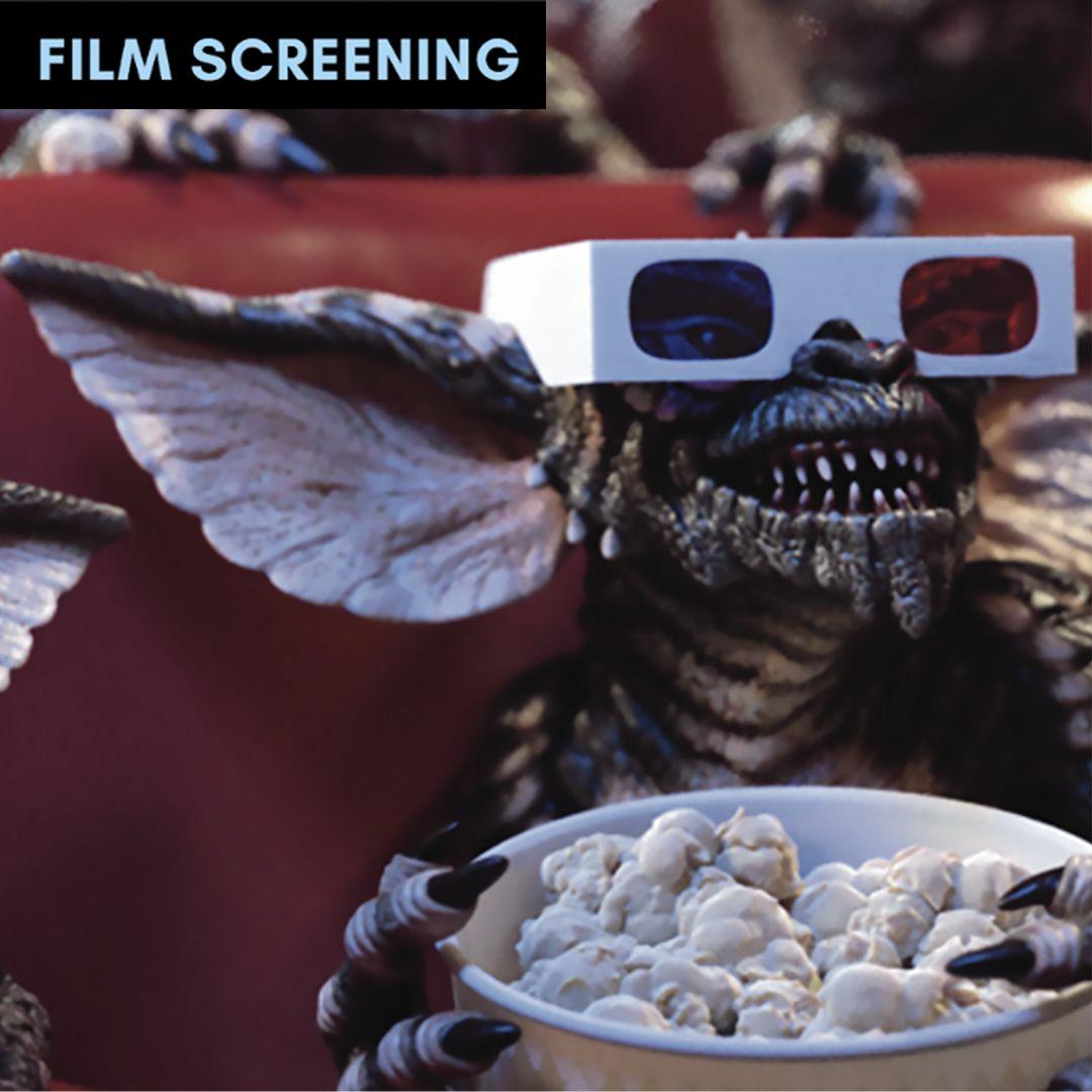 gremlin wearing 3D goggles and eating popcorn at theatre