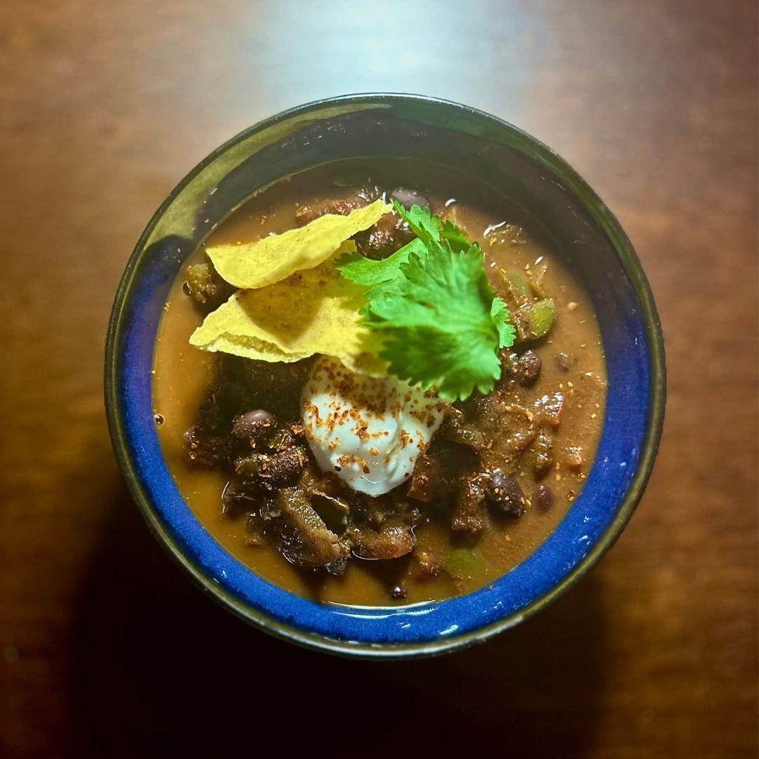 bowl of apple, squash and chipotle soup with nacho chip garnish