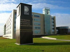 Regional Municipality of Durham Headquarters  surrounded by a landscaped lawn under a partly cloudy sky.