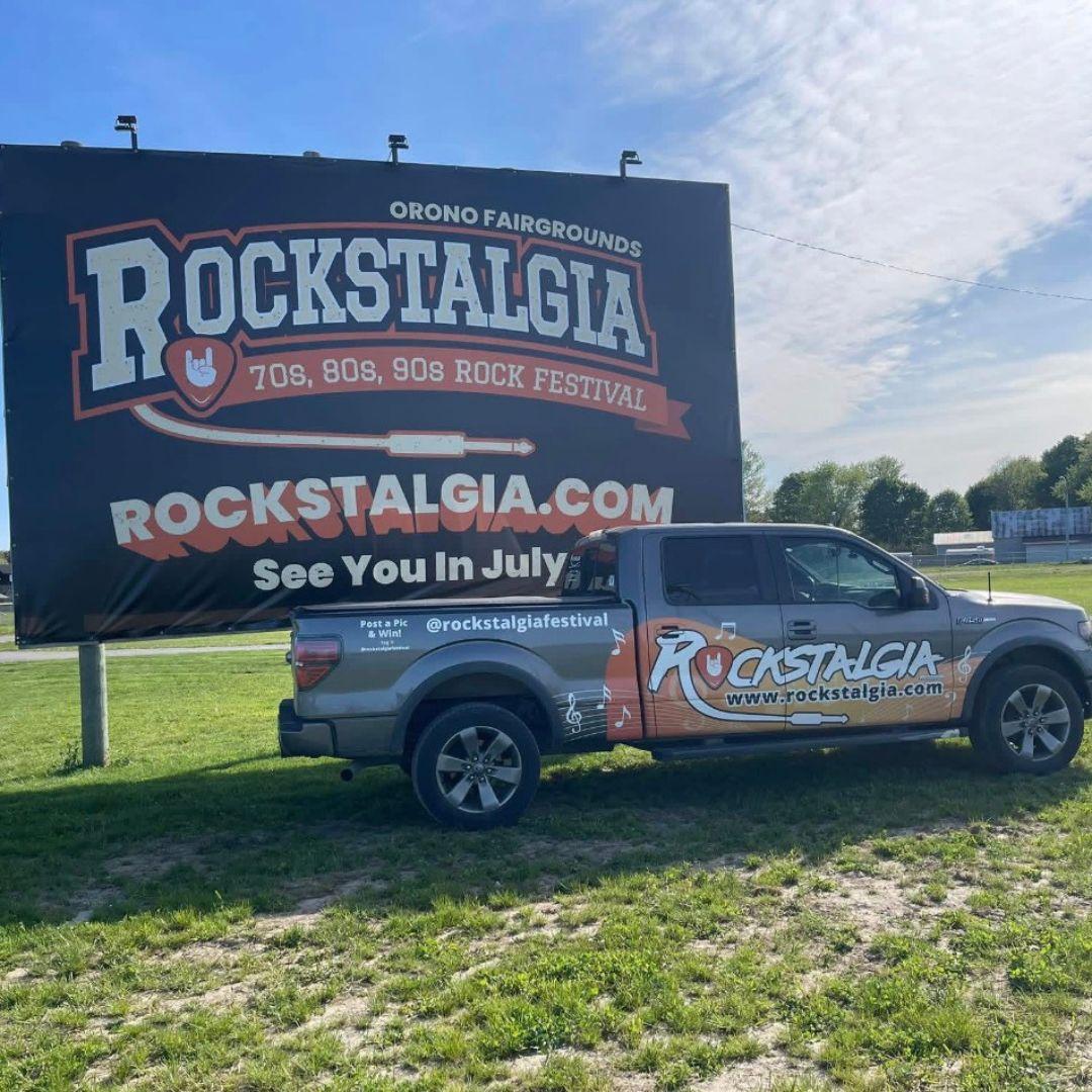 truck parked in front of a side advertising Rockstalgia