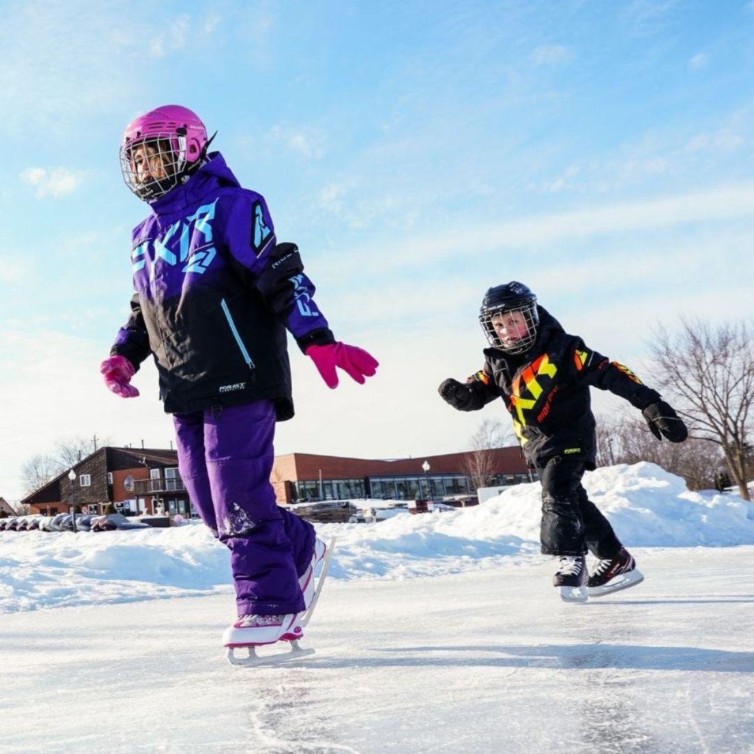 two children skating on outdoor rink