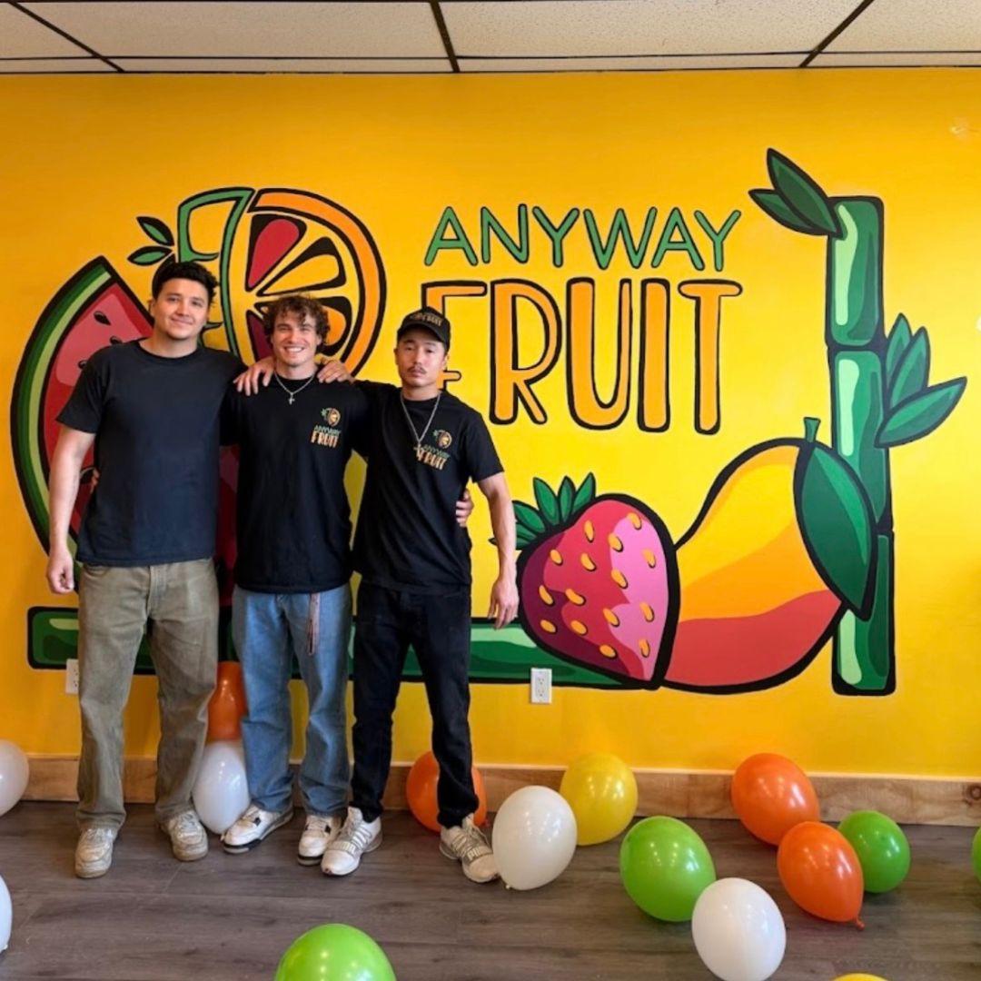 3 men stand together with balloons on the floor