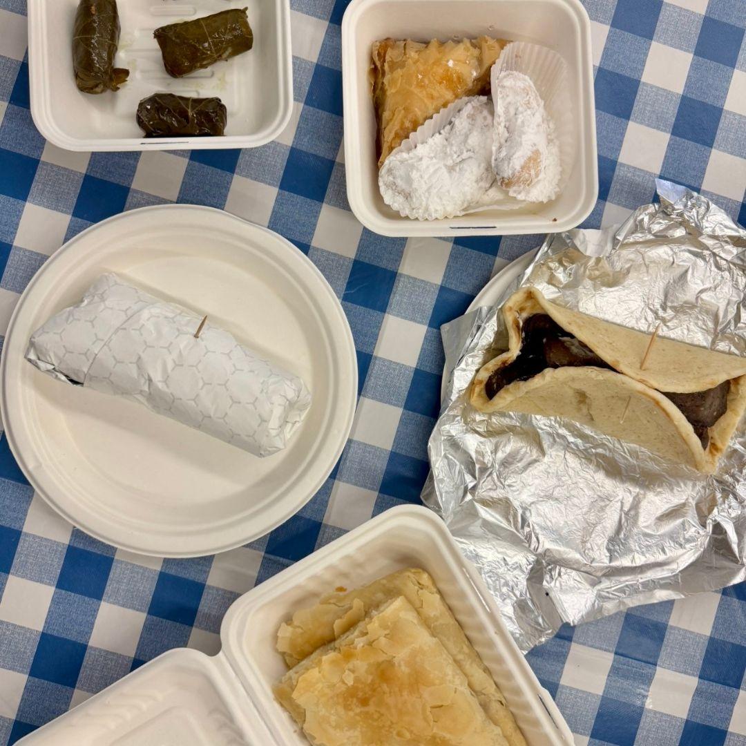 takeout food dishes spread out on a picnic blanket