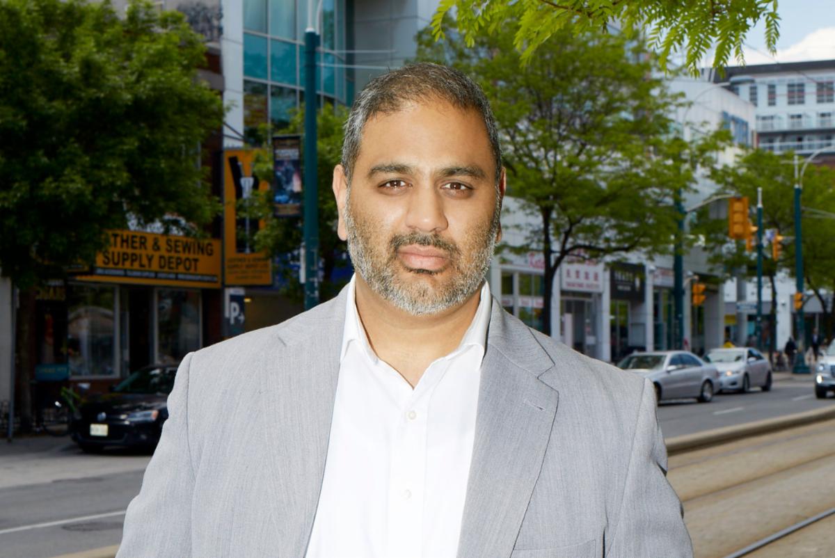 man stands on a street looking at the camera