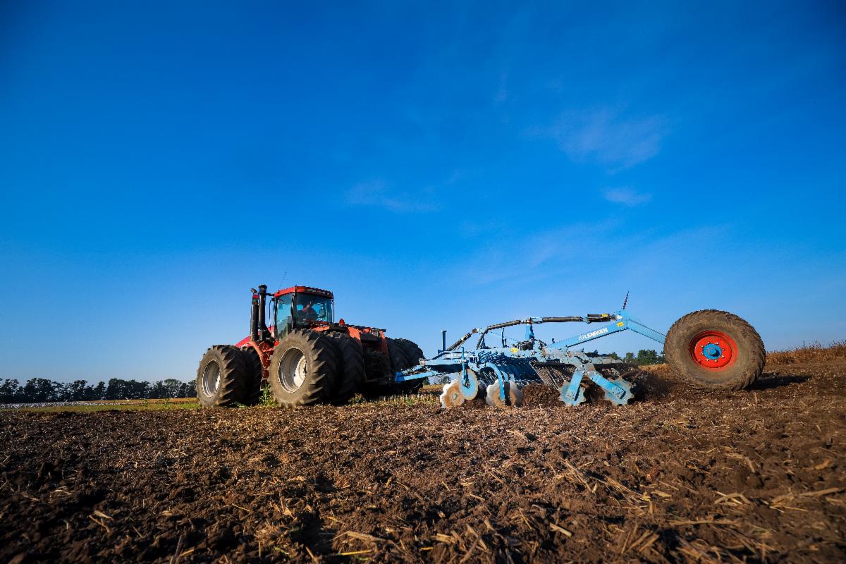 tractor and farm equipment in plowed field