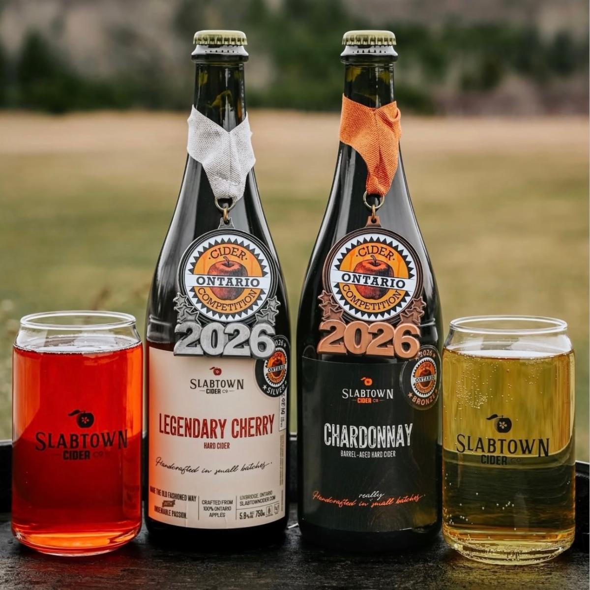 two bottles of cider with filled glasses on either side