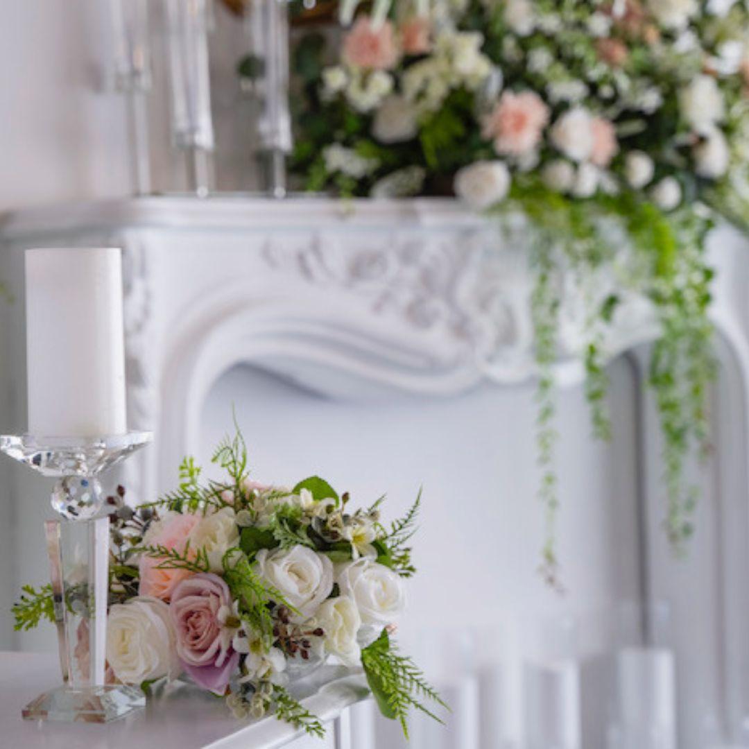 flowers adorn a white backdrop with candles