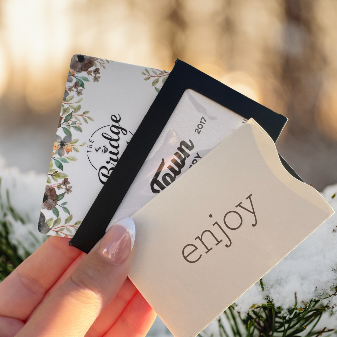 hand holding three gift cards