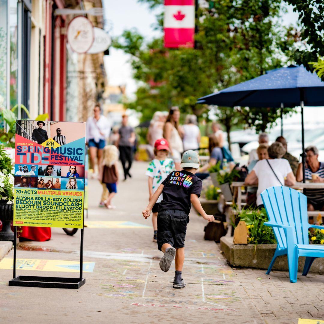 downtown sidewalk with storefronts and patios
