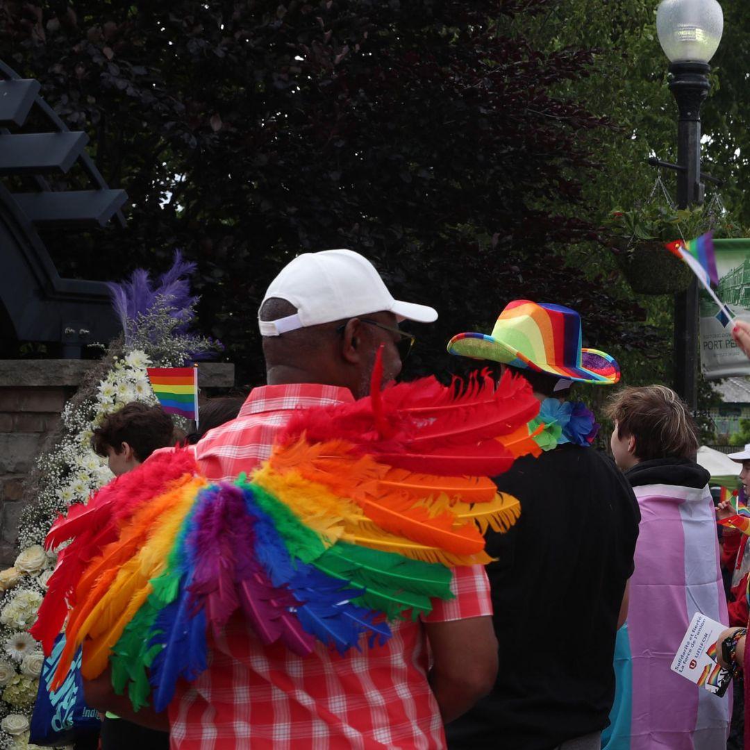 crowd of people dressed in rainbow gear