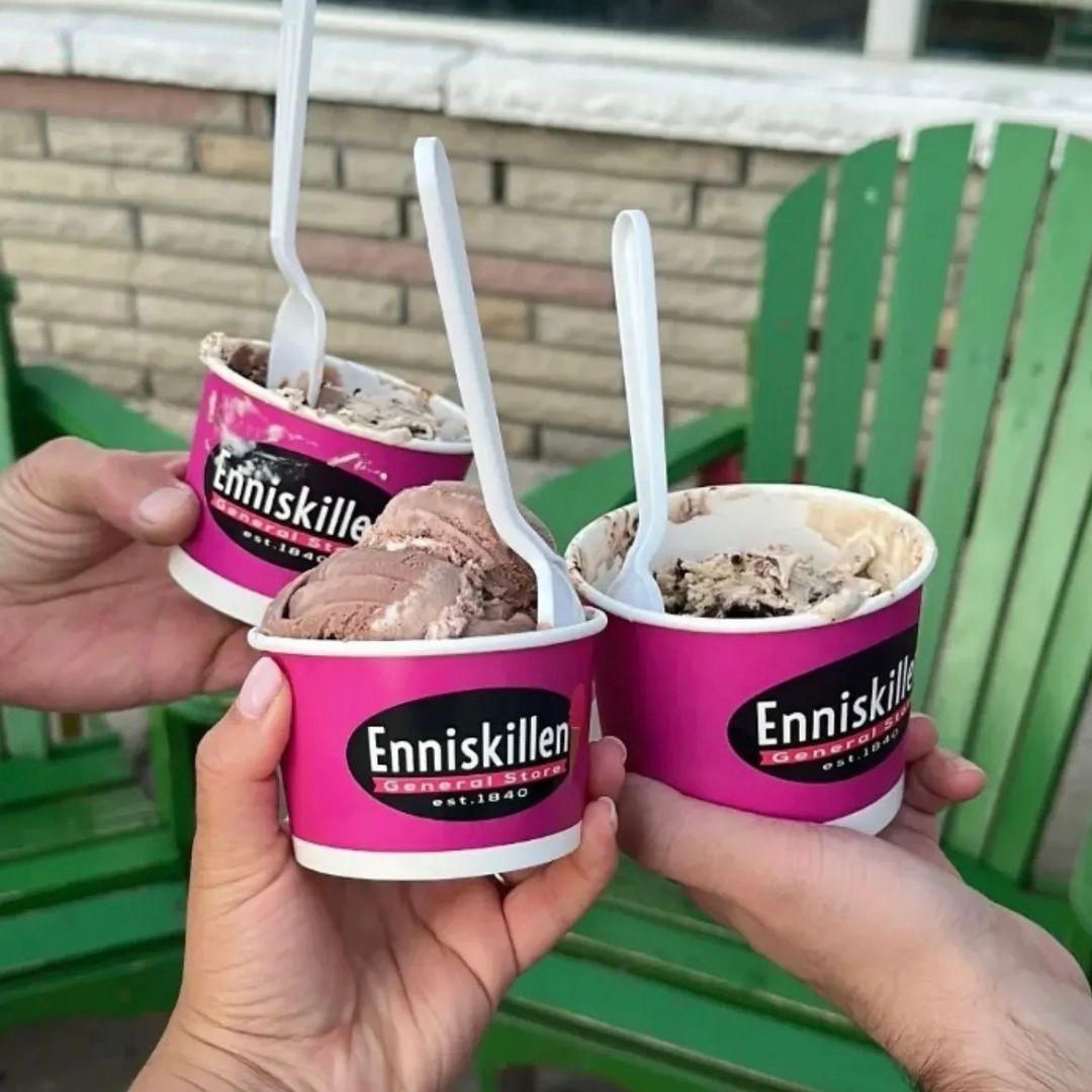 Hands holding up three small cups of ice cream