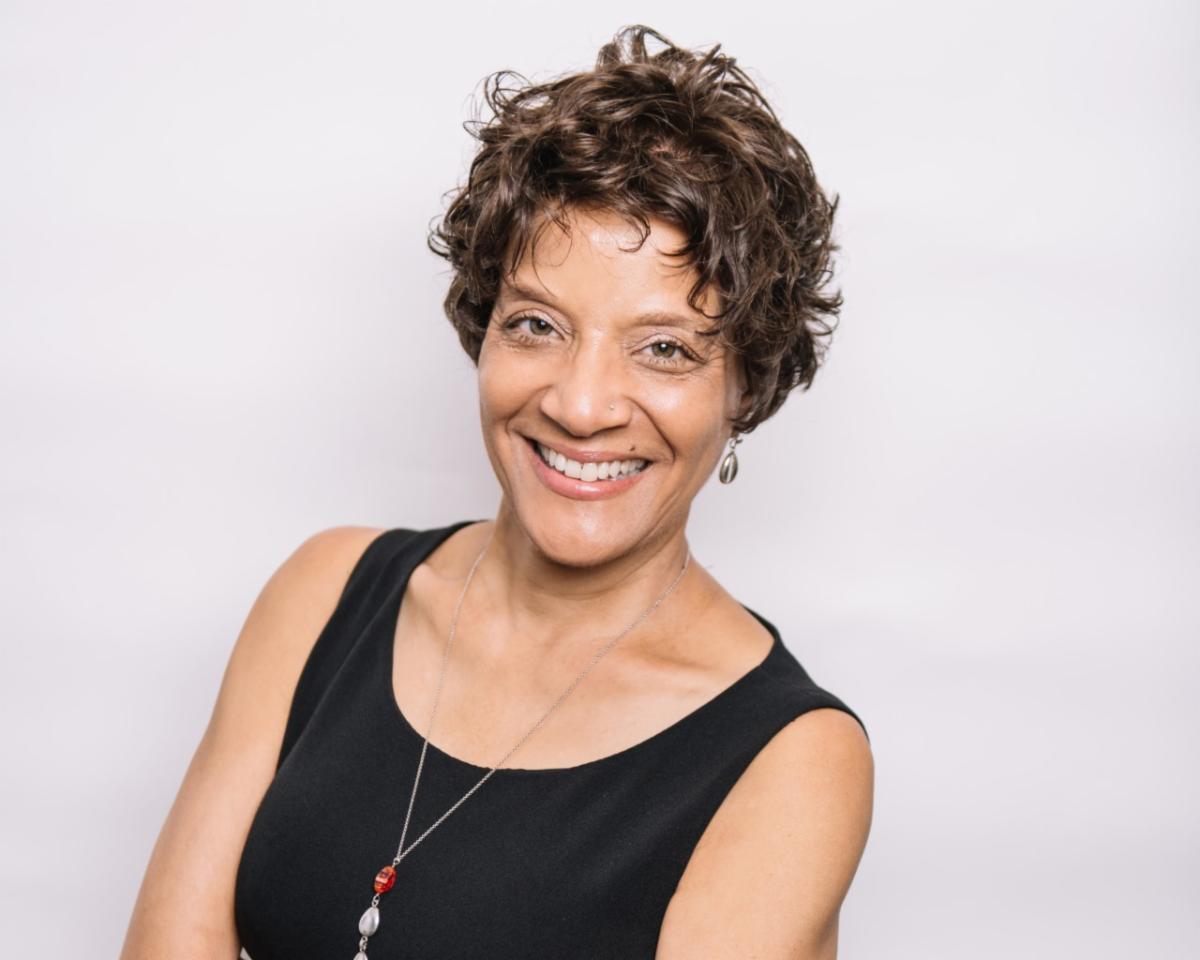Woman with black top and short curly hair