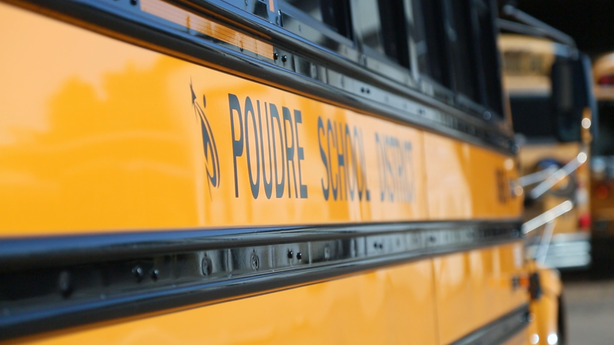 A close shot of the side of a yellow Poudre School District bus.
