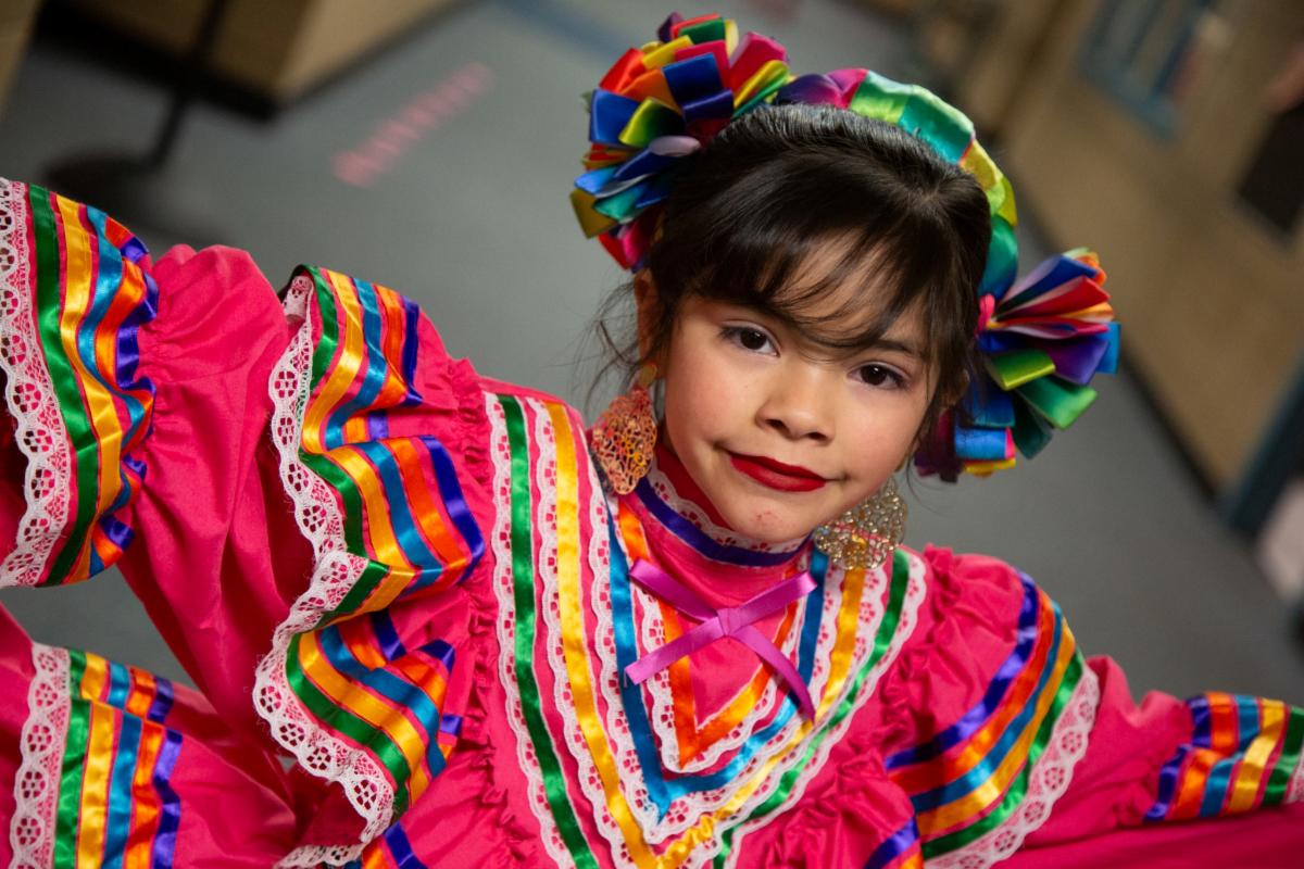  Una niña de escuela primaria muestra su vibrante y tradicional vestido de Mexico.
