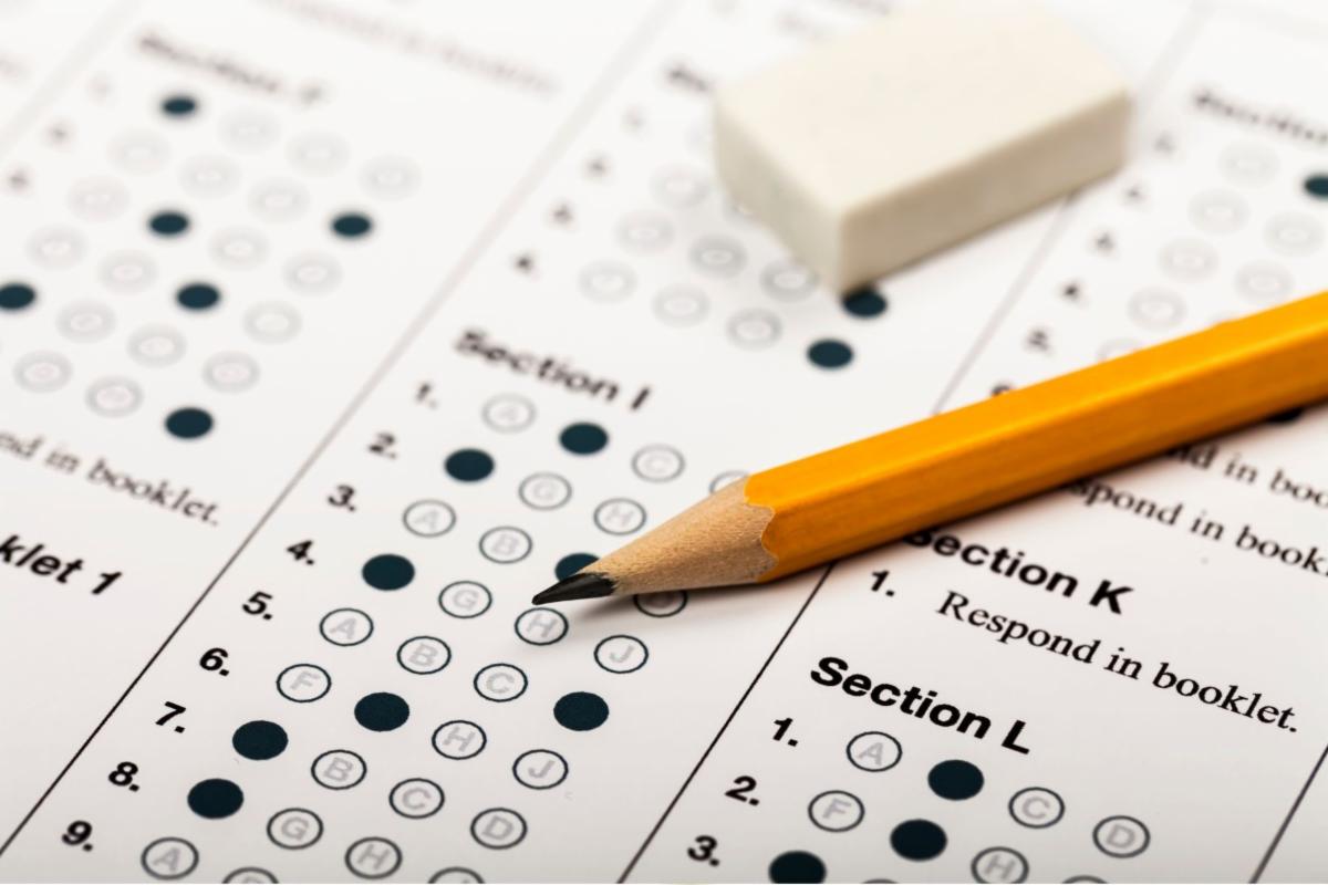 A test sheet with some bubbles filled in. A pencil rests on top of the test sheet.