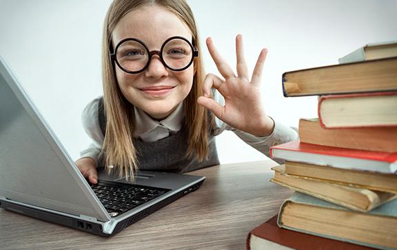 girl using a laptop and studying with books