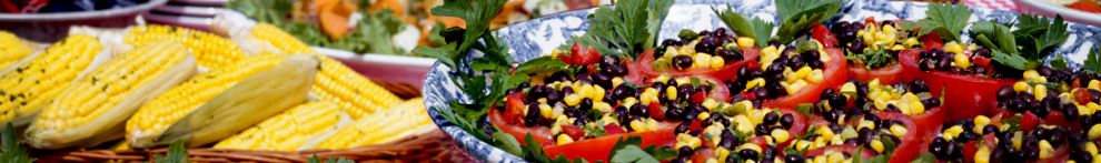 Photo of a bowl of corn on the cob and some bean and corn salad.
