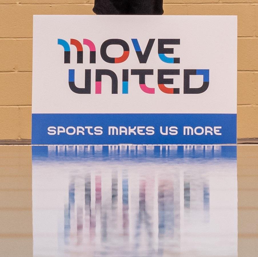 Move United - Sports Make Us More Sign positioned next to a pool, sign reflecting in the water
