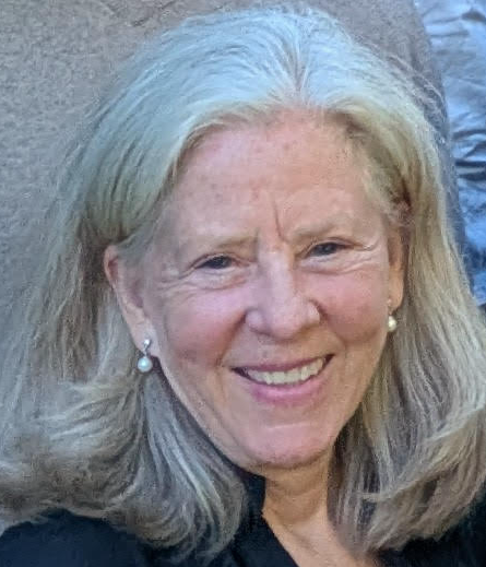 Catherine wearing pearl earrings smiling at the camera