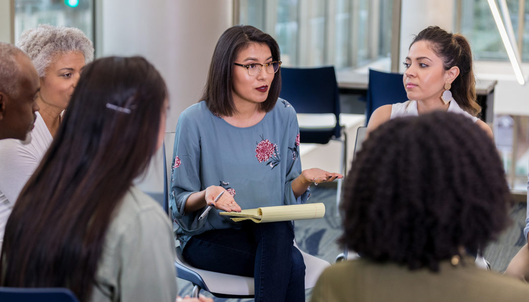 Woman speaking in a crowd of people
