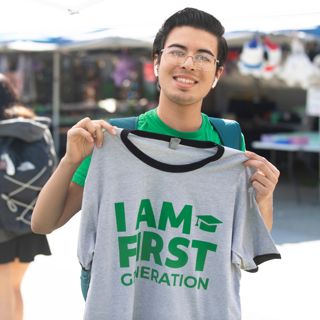 Student holding an I Am First Tshirt