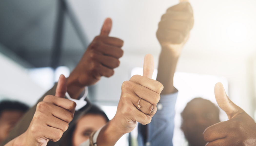 Team members showing a thumbs up